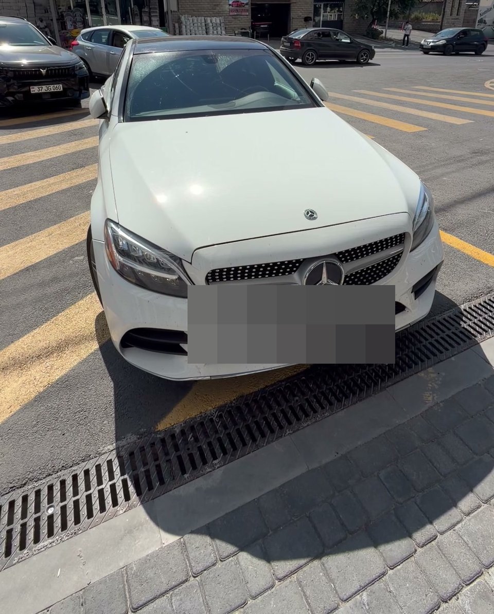 A car standing on the striped pedestrian crossing, single car, plate visible